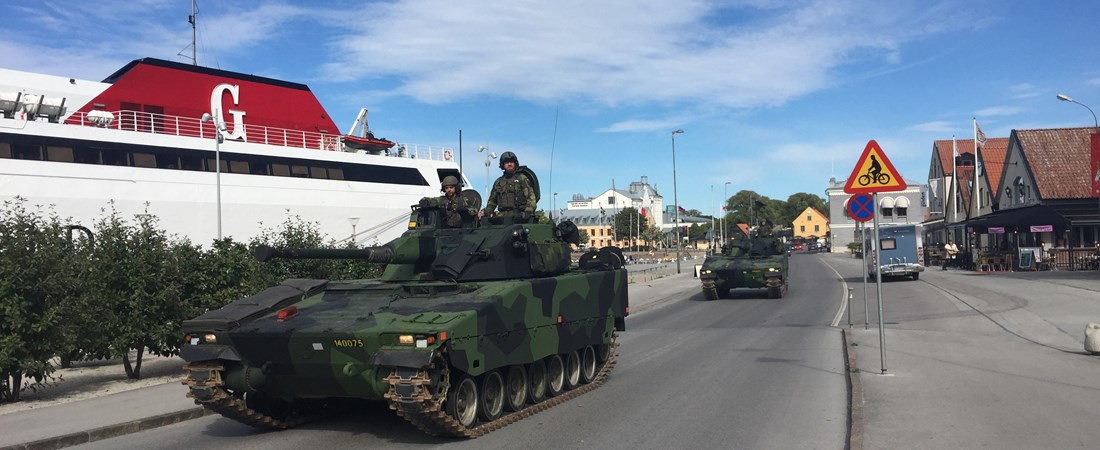 Militärkolonn på Gotland framför passagerarfartyg.
