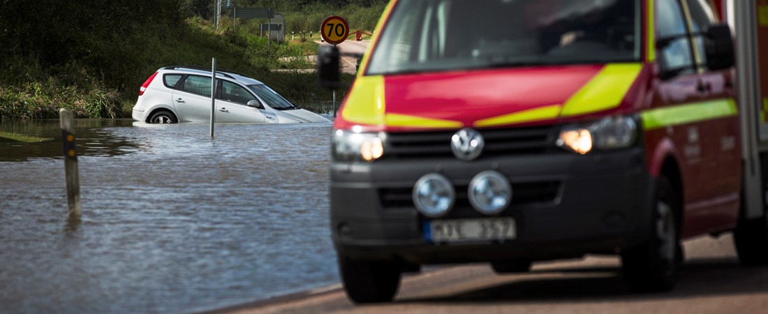 Räddningsbil vid en översvämmad väg