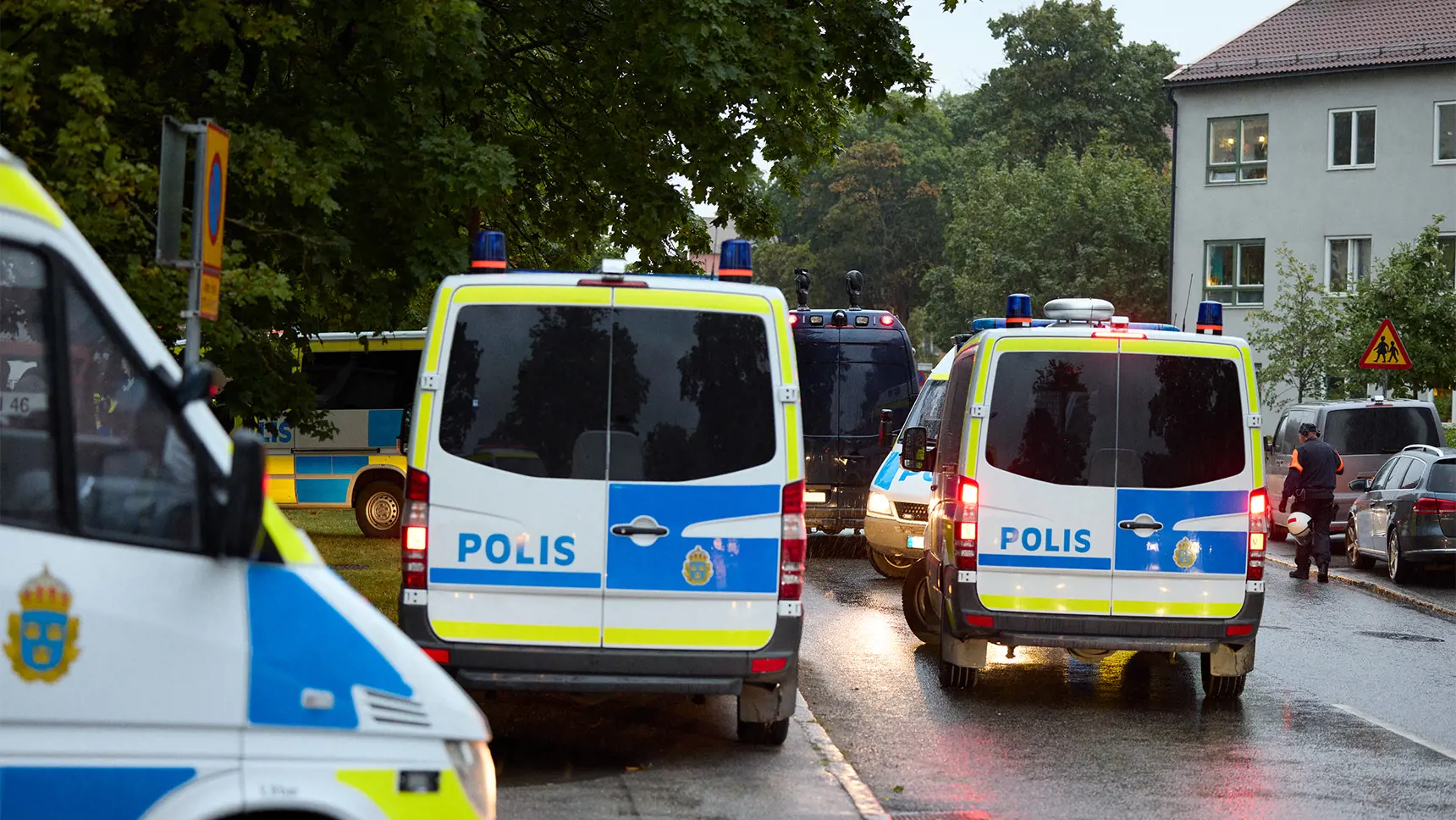 Flera polisbilar står parkerade i ett bostadsområde.