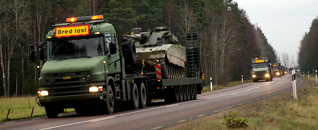 Militärkolonn med transport av pansarvagnar.