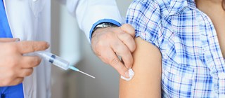 Person vaccineras i armen med spruta
