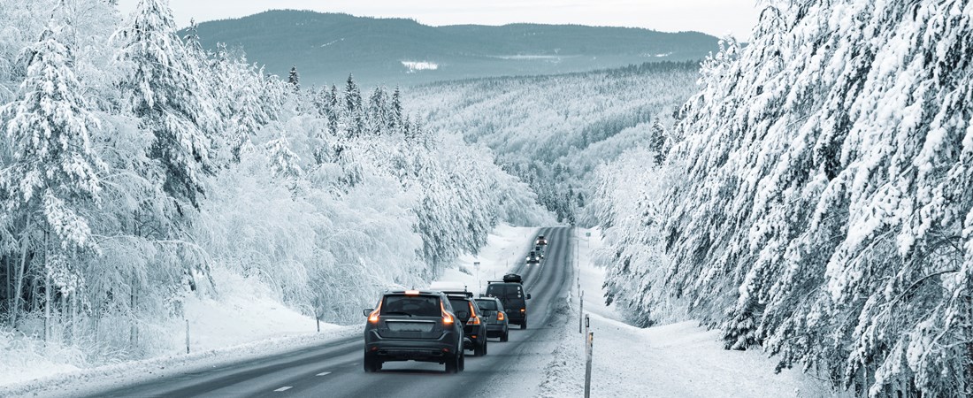 Bilar på väg till och från fjällen i ett vintrigt landskap.