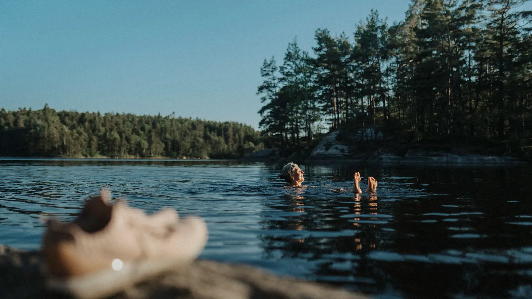 Kvinna som badar i en sjö