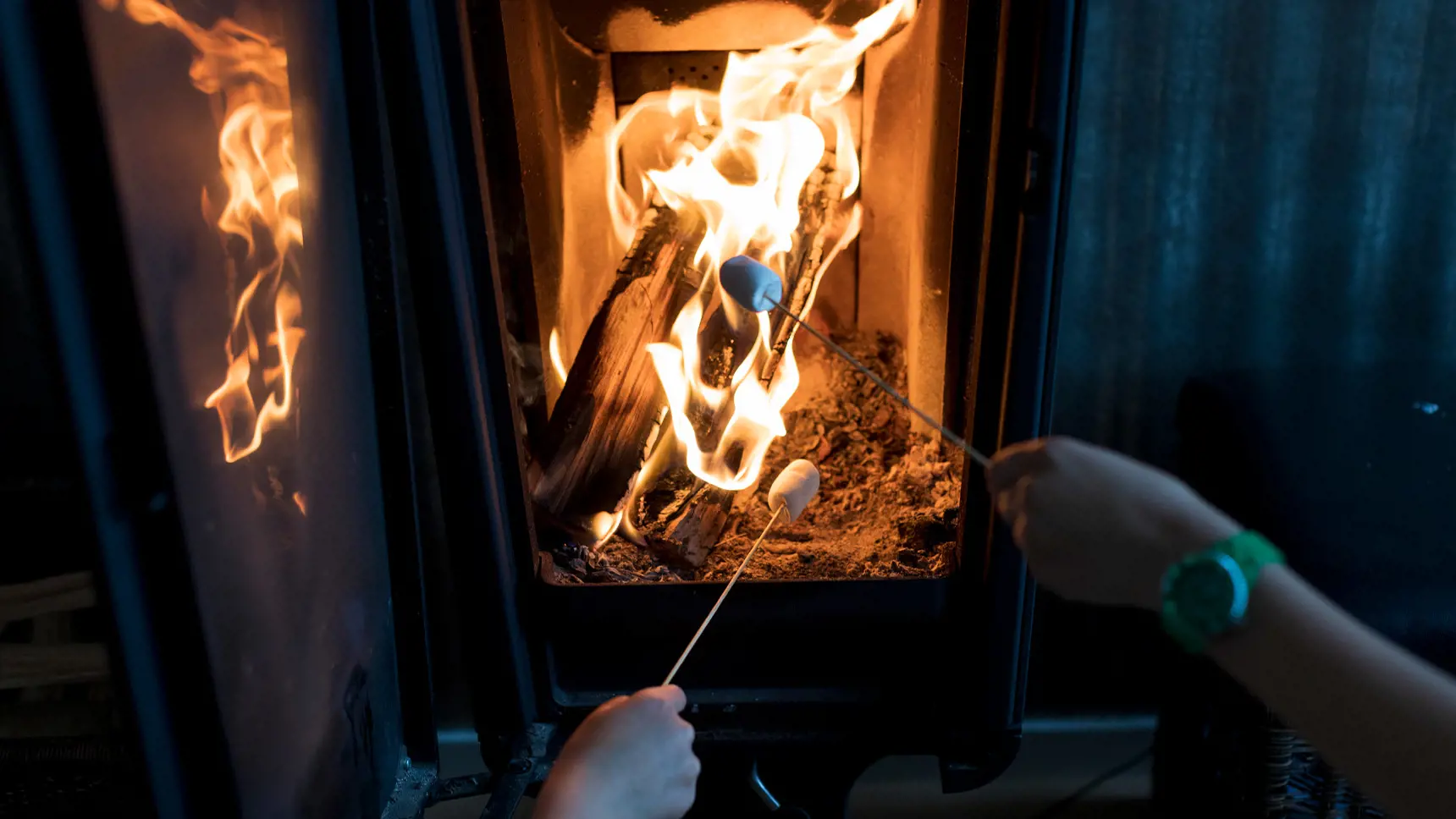 Barn grillar mashmellows i kamin inomhus