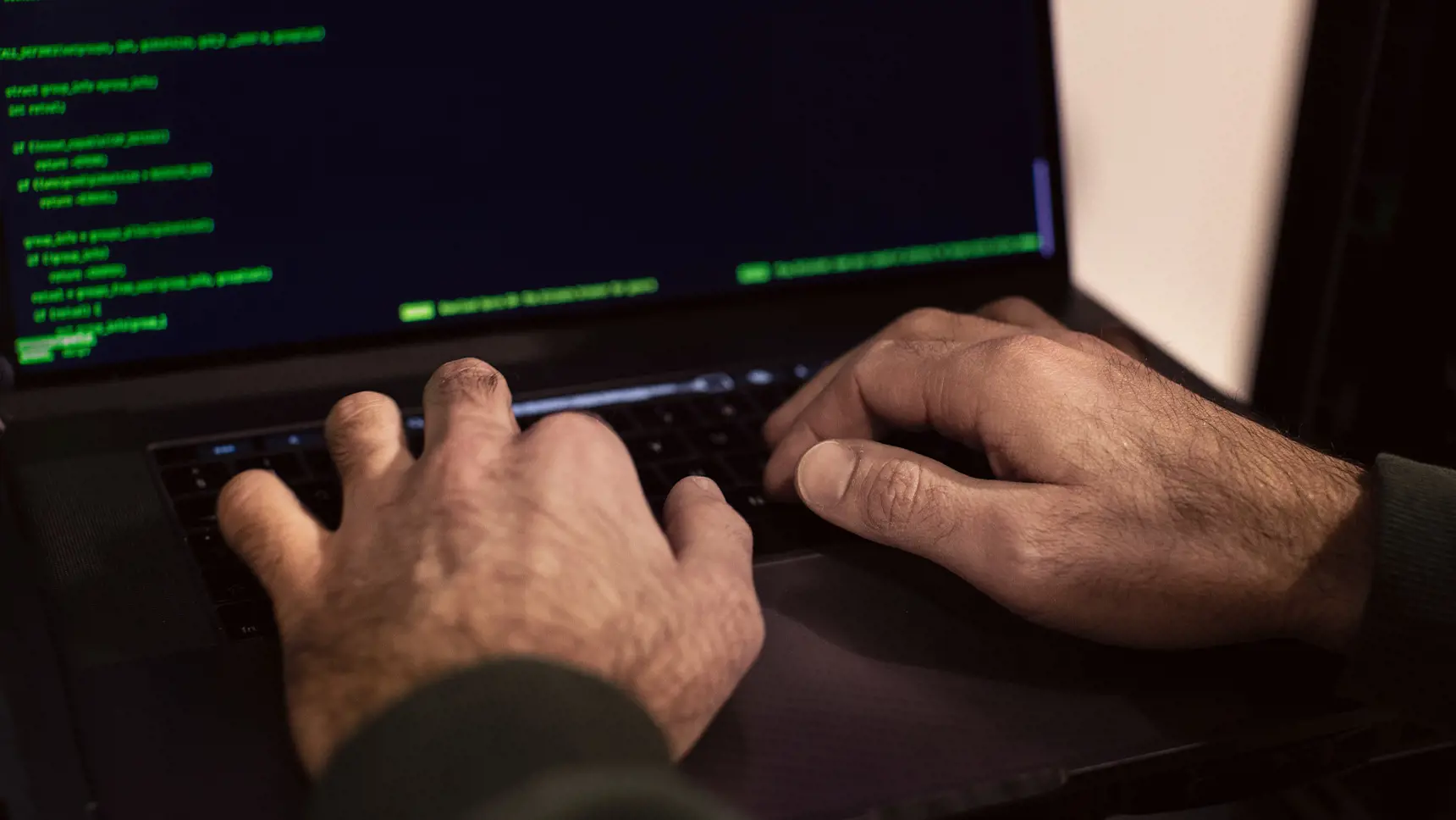Händer som knappar in kod på en dator