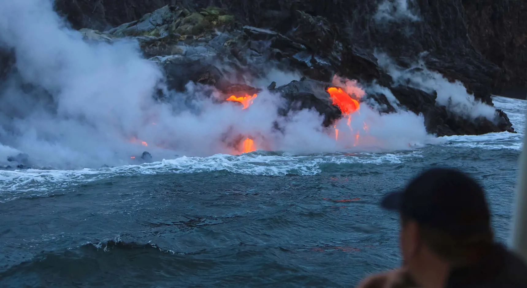 Bild på lava från vulkanutbrott som rinner ner i havet