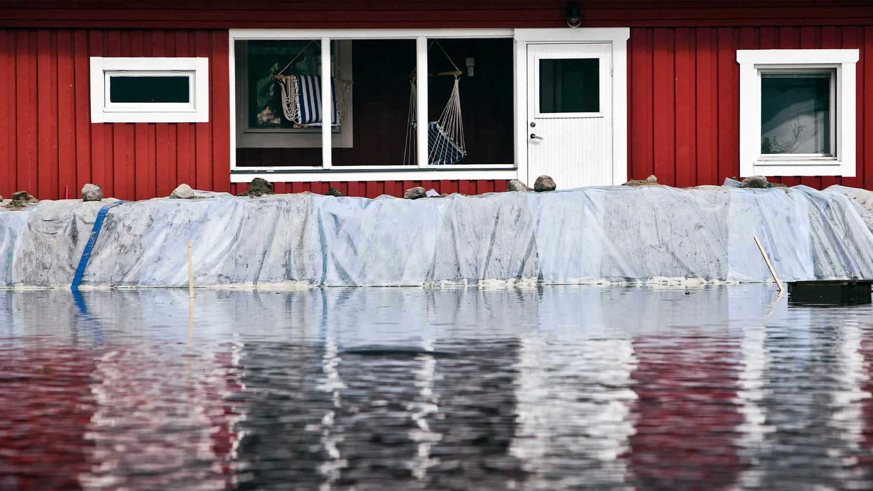Översvämmat hus med barriär mot vattnet.