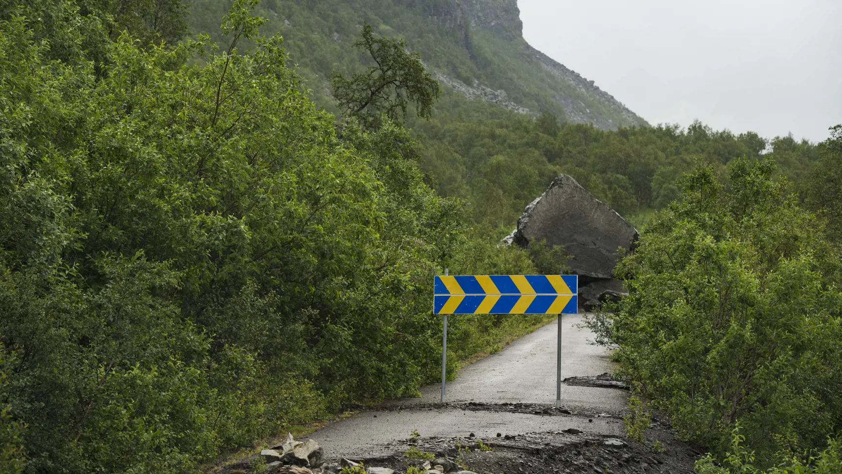 Stenblock på väg. Bergigt landskap.