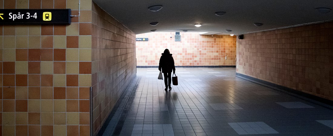 Person som går i en mörk gångtunnel.