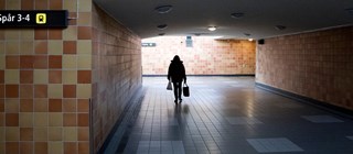 Person som går i en mörk gångtunnel.