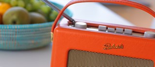 Radioapparat på köksbord med en fruktskål.