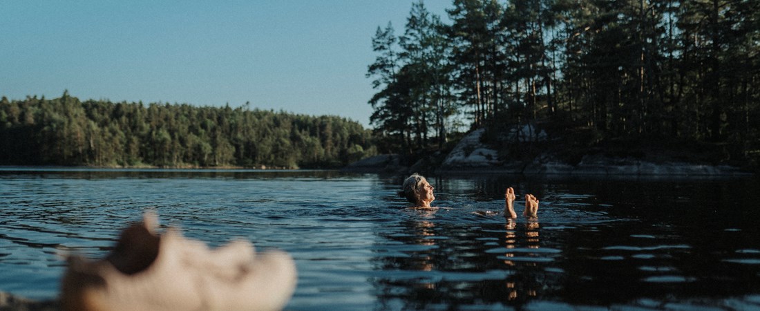 Kvinna som badar i en sjö. 