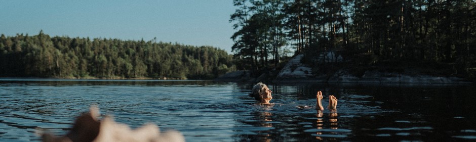 Kvinna som badar i en sjö. 