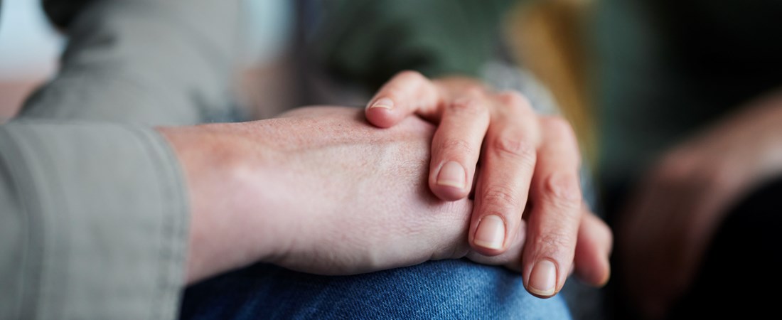 En hand som håller en annan människas hand. 