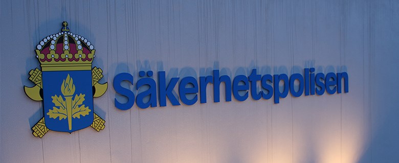 Säkerhetspolisens kontor med logotypen för Säkerhetspolisen placerad på en upplyst betongfasad.