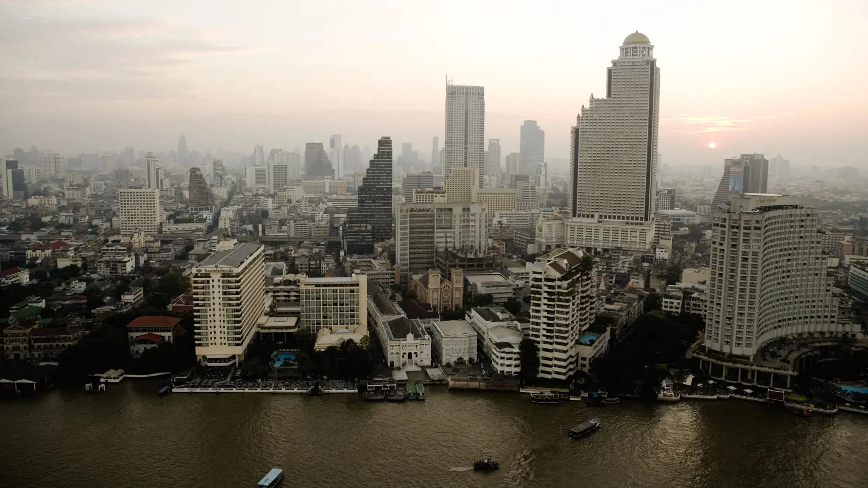 Bangkok sett uppifrån. Skyskrapor med vattenlinjen i förgrunden.
